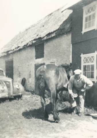 Karl Hallander Allmunds 872, född 1908, skor hästen Rune utanför ladugården där man i dag kan se fin konst på sonen Karl Johan Hallanders sommargalleri.